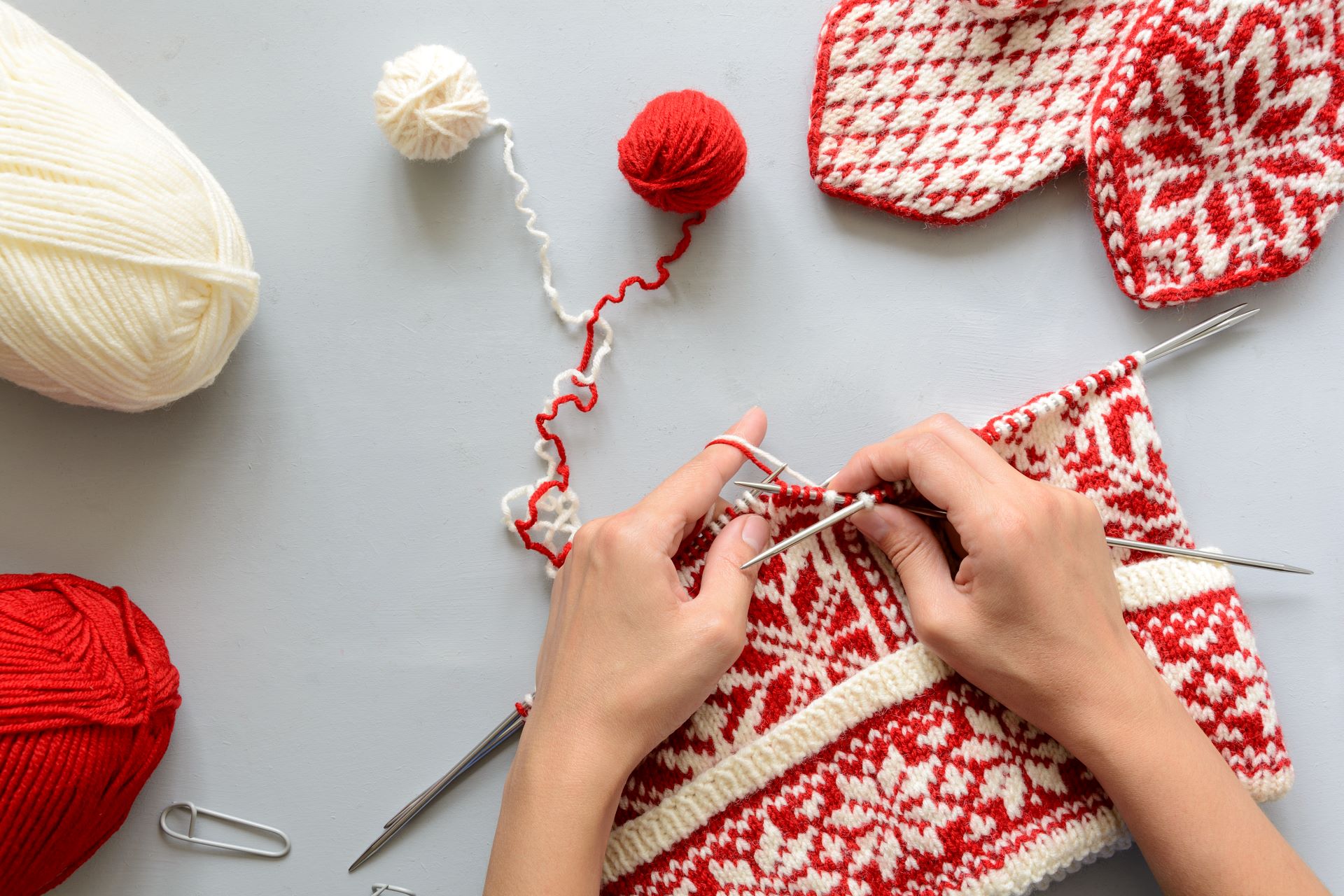 Strickprojekt mit roten und weißen Mustern und Baby Alpaka Wolle