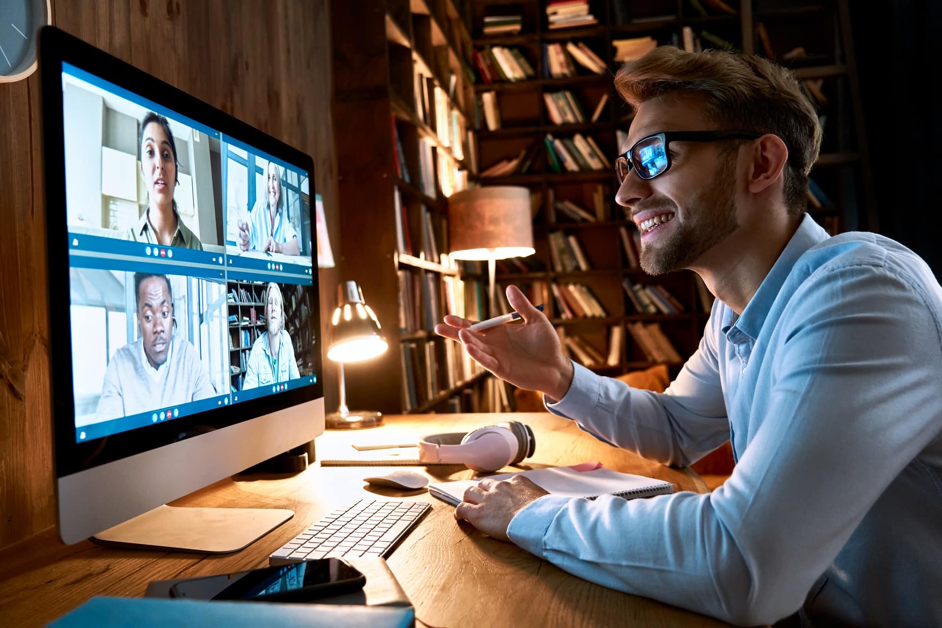 Videokonferenz mit Kollegen vor Buecherregal | PIM System